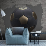 Fotomurales Un balón de fútbol atraviesa una pared de ladrillos.