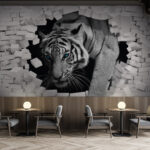 Fotomurales Tigre atravesando muro de ladrillo blanco.