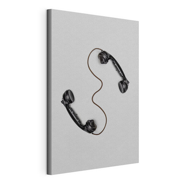 Cuadros Un auricular de teléfono negro sobre una superficie blanca