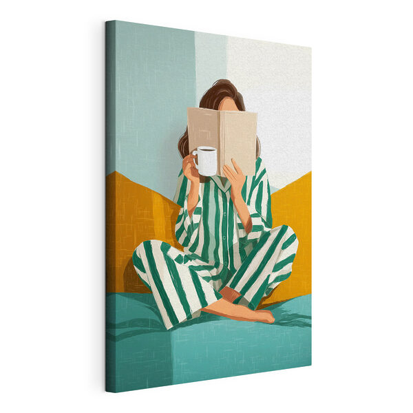 Una mujer sentada en una cama con un libro y una taza Cuadros Una mujer sentada en una cama con un libro y una taza