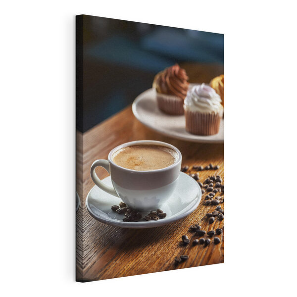 Cuadros Una taza de café y unos cupcakes sobre una mesa
